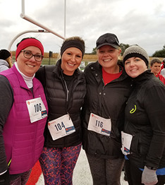 Four adult women outside near a track